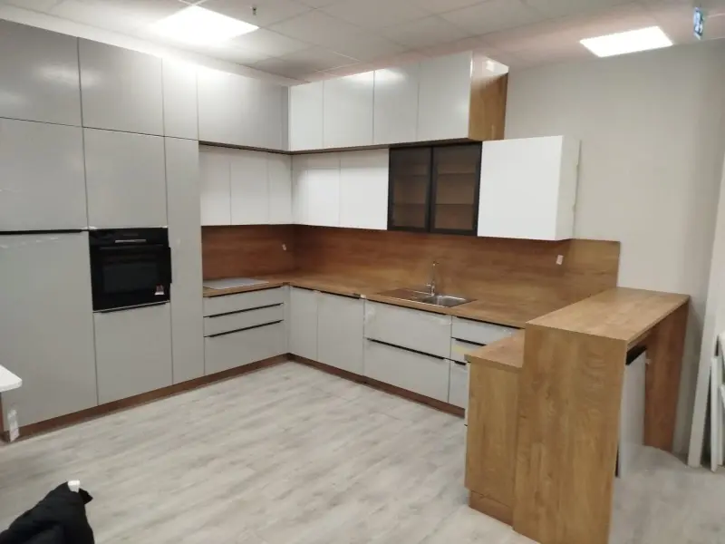 Bijela U-kuhinja s drvenom radnom pločom, barpultom i staklenom vitrinom - montaža namještaja Hrvatska