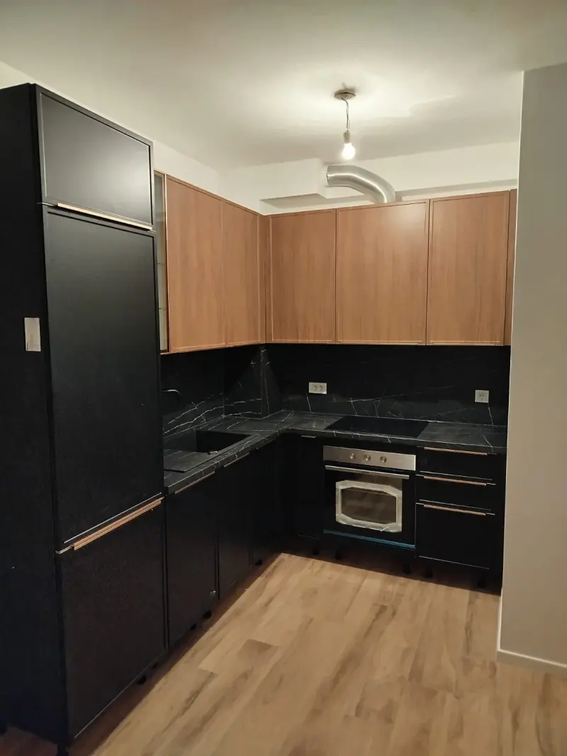 L-kuhinja s crnim donjim elementima, drvenim gornjim ormarićima i mramornom radnom pločom - montaža kuhinja Samobor